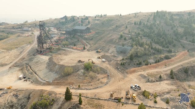 Wide aerial view across the workings, headframes and haul roads through the district
