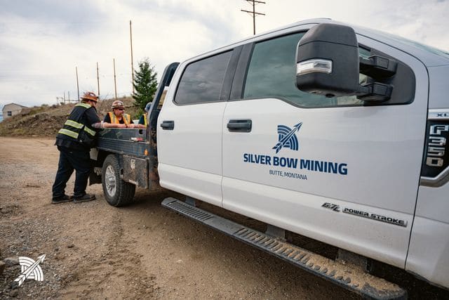 Crew beside a Silver Bow Mining pickup on the property road
