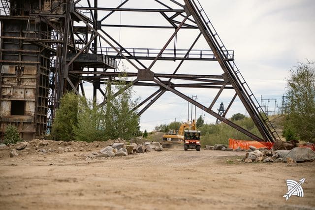 The riveted steel legs of a headframe seen from below