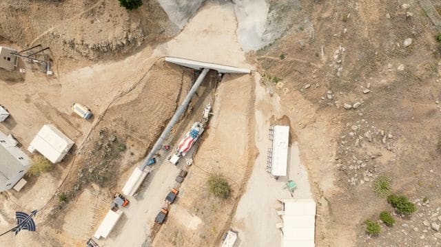 Aerial view down onto the portal bench, trailers and vehicles along the cut