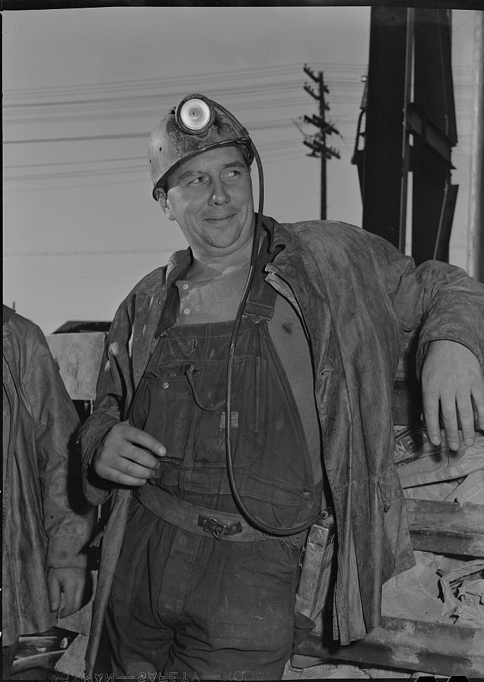 An Anaconda copper miner in oilskins and carbide lamp, smiling, September 1942