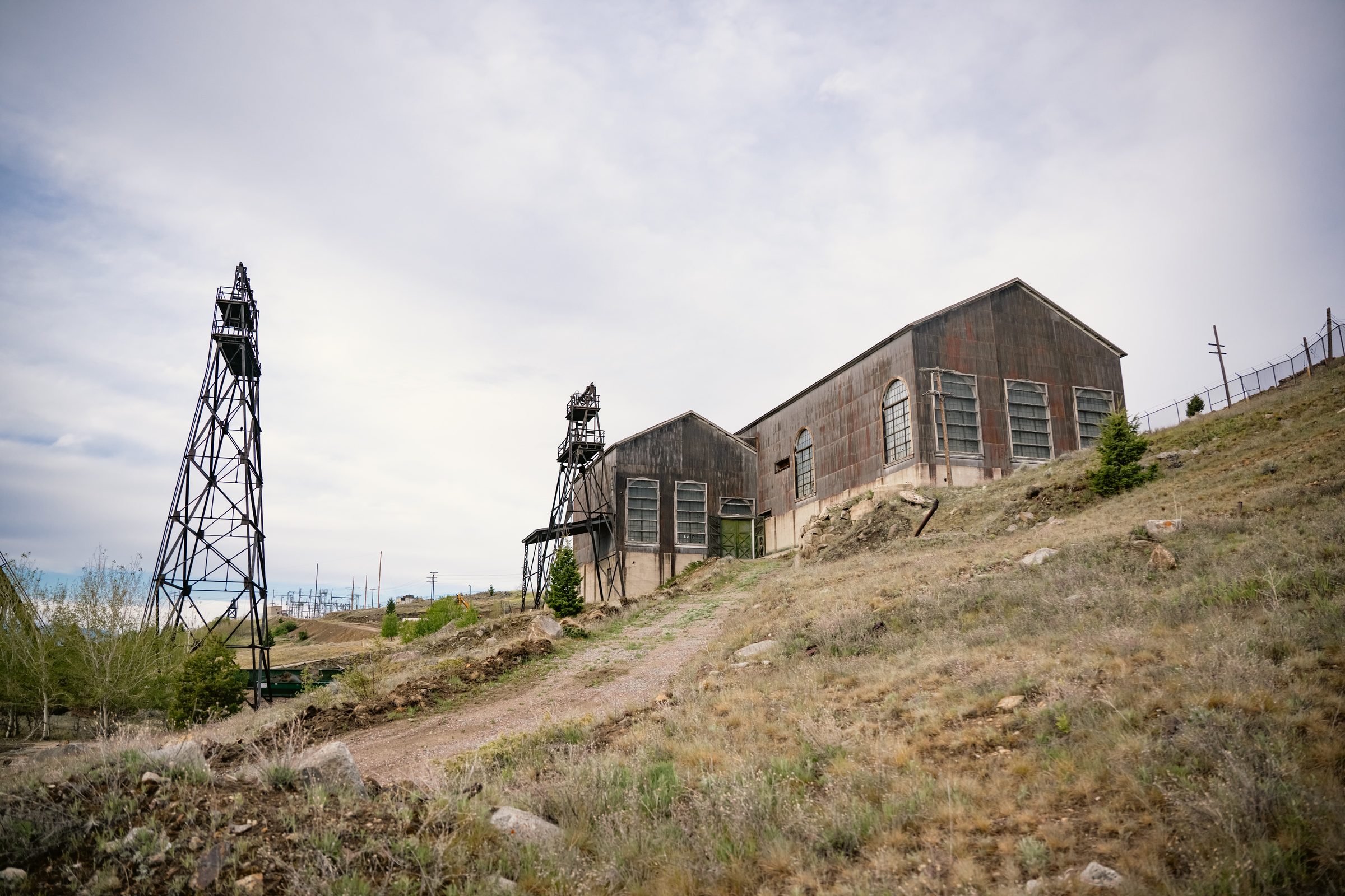 Historic hoist houses and two headframes standing on a grassy hillside above Walkerville